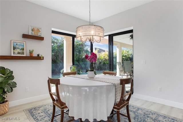 dining room featuring ceiling fan with notable chandelier and wood-type flooring