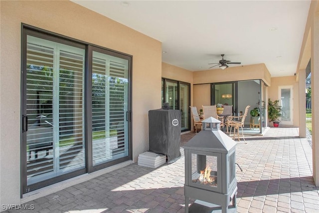 view of patio / terrace featuring a fire pit and ceiling fan