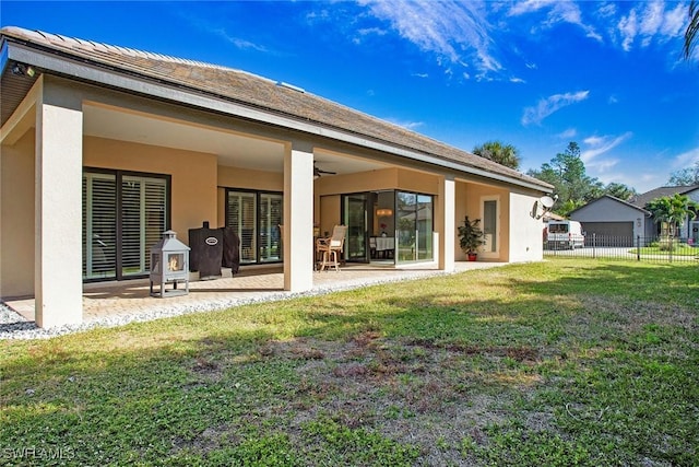 back of house with a lawn and a patio