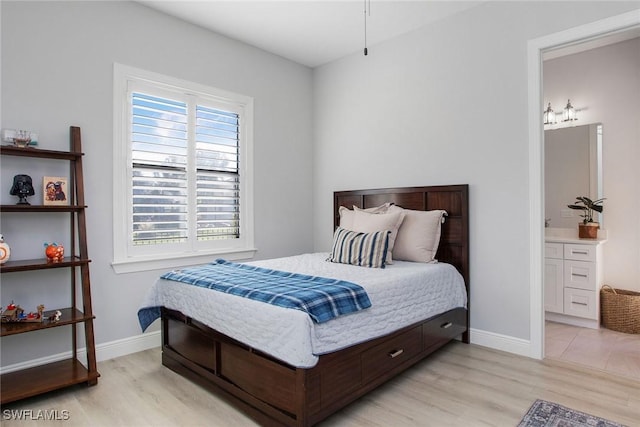 bedroom featuring ensuite bath and light hardwood / wood-style flooring