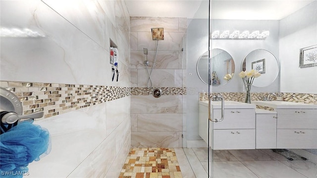 bathroom with vanity, tile walls, and tiled shower