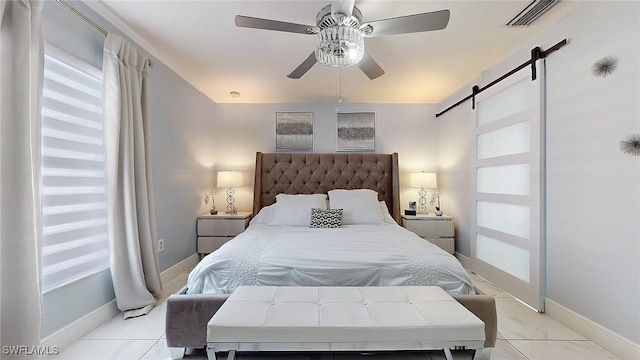 bedroom featuring a barn door and ceiling fan