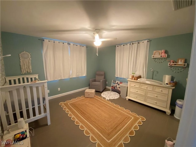 bedroom featuring a nursery area and ceiling fan