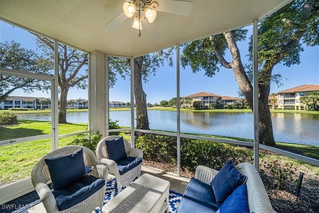 sunroom featuring ceiling fan and a water view