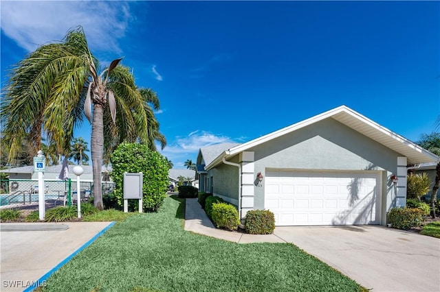 view of side of home with a garage and a lawn