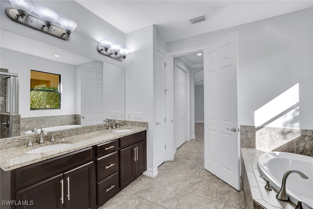 bathroom featuring vanity and tiled tub