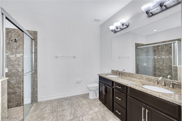 bathroom featuring vanity, toilet, a shower with shower door, and tile patterned flooring