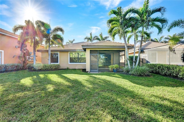 rear view of property featuring a lawn