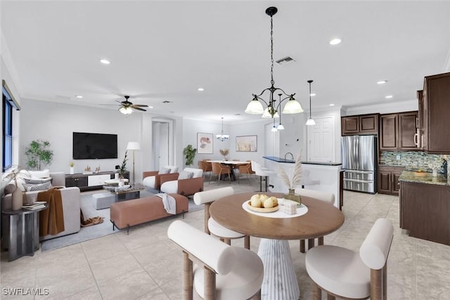 dining room with crown molding, ceiling fan with notable chandelier, and light tile patterned floors