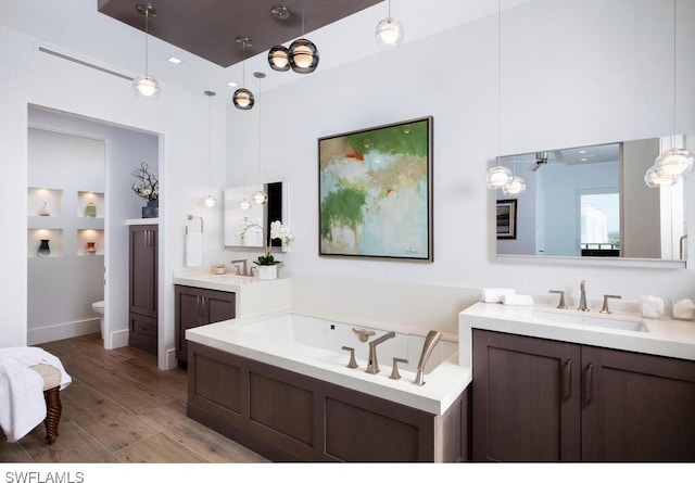 bathroom with vanity, hardwood / wood-style floors, and a washtub