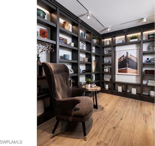 sitting room with wood-type flooring and track lighting