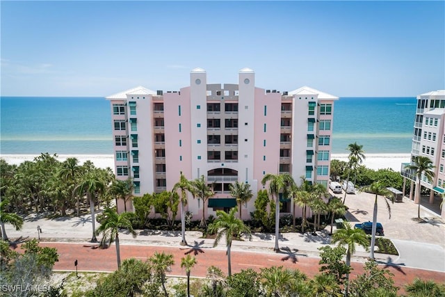 view of building exterior with a water view and a beach view