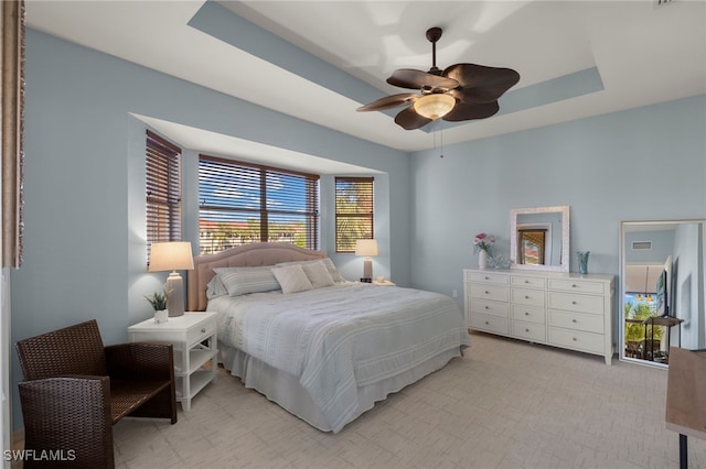 bedroom with a raised ceiling and ceiling fan