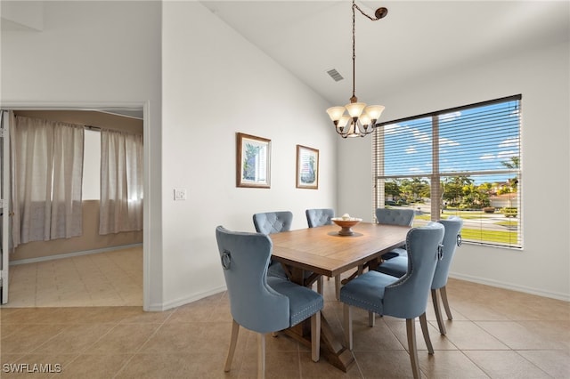 tiled dining area featuring high vaulted ceiling and a chandelier