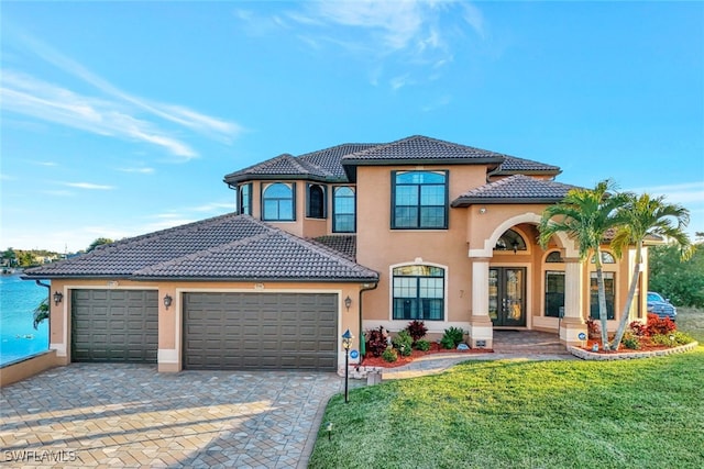 mediterranean / spanish-style home with a garage and a front lawn