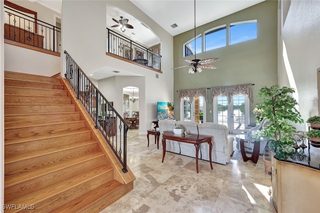 living room with french doors and ceiling fan with notable chandelier