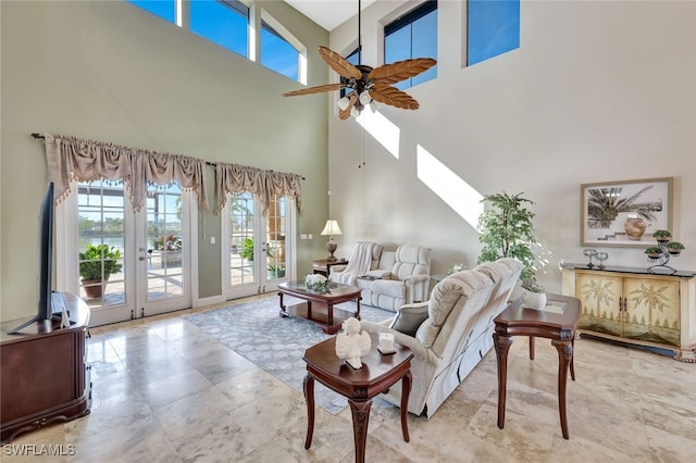 living room featuring french doors, ceiling fan, and a towering ceiling