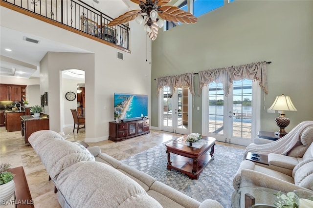 living room featuring a towering ceiling, french doors, and ceiling fan