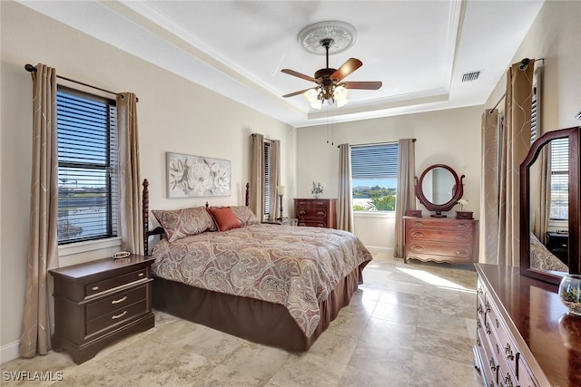 bedroom with a raised ceiling, crown molding, and ceiling fan