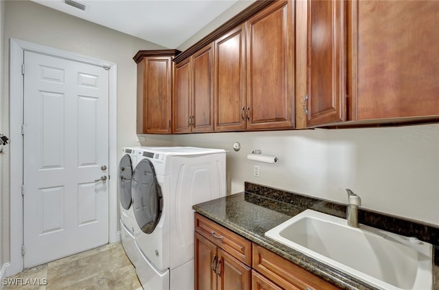 clothes washing area with sink, cabinets, and washing machine and clothes dryer