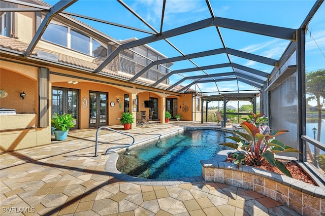 view of swimming pool with french doors, a lanai, and a patio