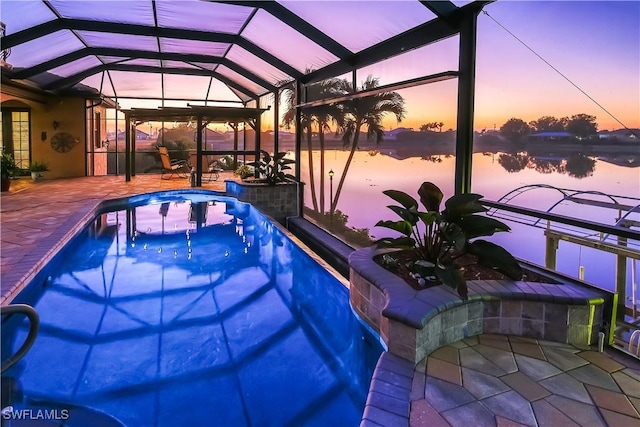 pool at dusk with a water view, a lanai, and a patio