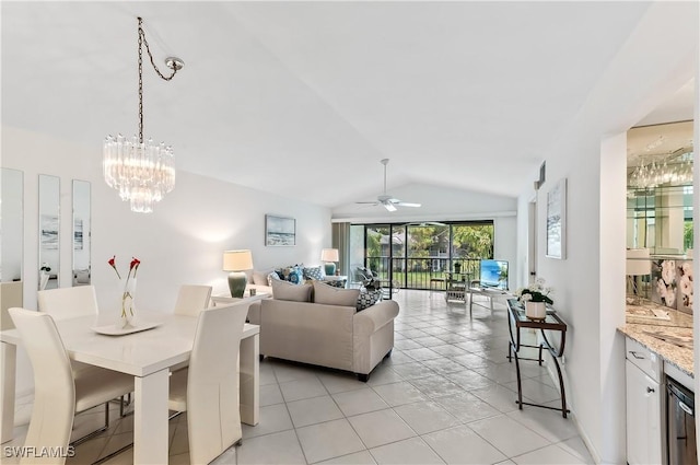 living room with ceiling fan with notable chandelier, vaulted ceiling, and light tile patterned floors