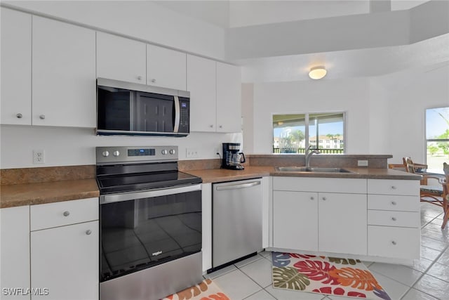 kitchen featuring white cabinetry, sink, stainless steel appliances, and kitchen peninsula