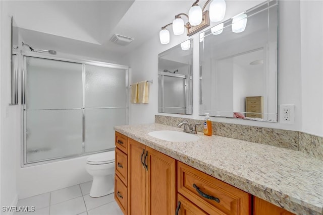 full bathroom with tile patterned flooring, vanity, enclosed tub / shower combo, and toilet