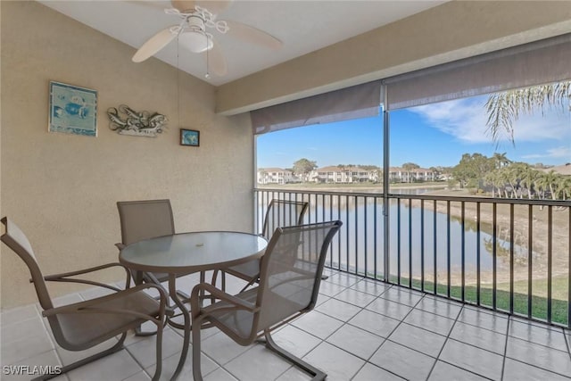 sunroom featuring a water view and ceiling fan