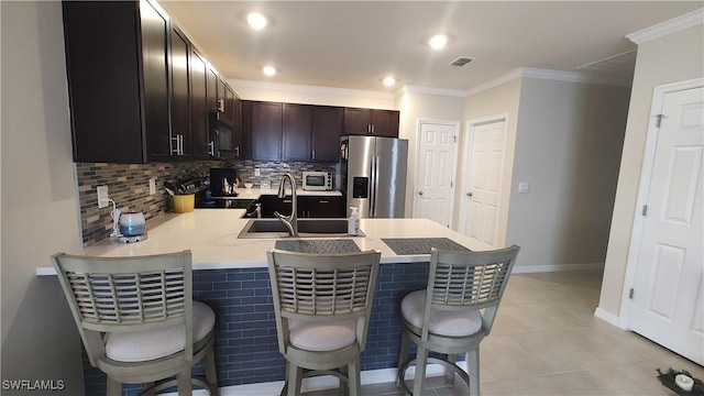 kitchen featuring stainless steel fridge, a breakfast bar area, range with electric cooktop, light tile patterned flooring, and kitchen peninsula