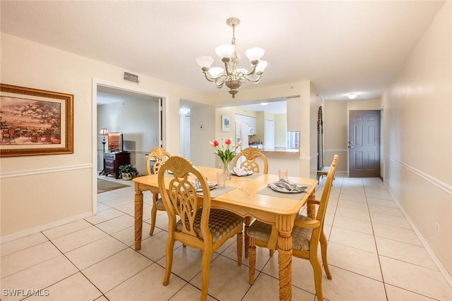 tiled dining area featuring an inviting chandelier