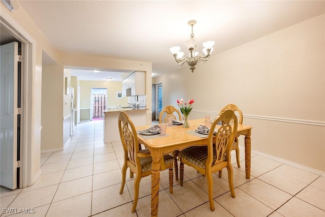 dining space featuring a notable chandelier, sink, and light tile patterned flooring