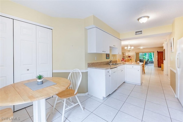 kitchen featuring sink, white cabinetry, decorative light fixtures, white dishwasher, and kitchen peninsula