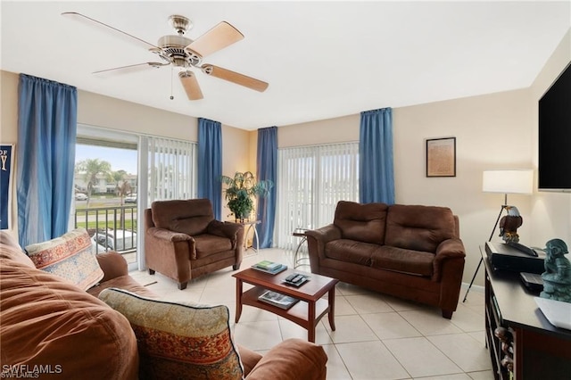 living room with a wealth of natural light, ceiling fan, and light tile patterned flooring