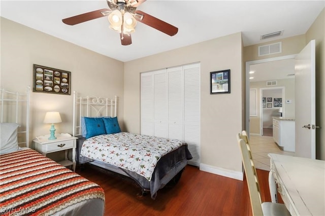 bedroom with dark hardwood / wood-style floors, ceiling fan, and a closet