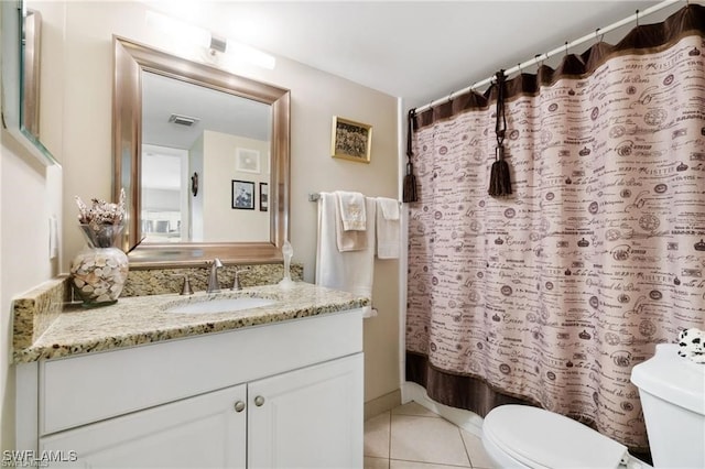 bathroom featuring vanity, tile patterned floors, and toilet