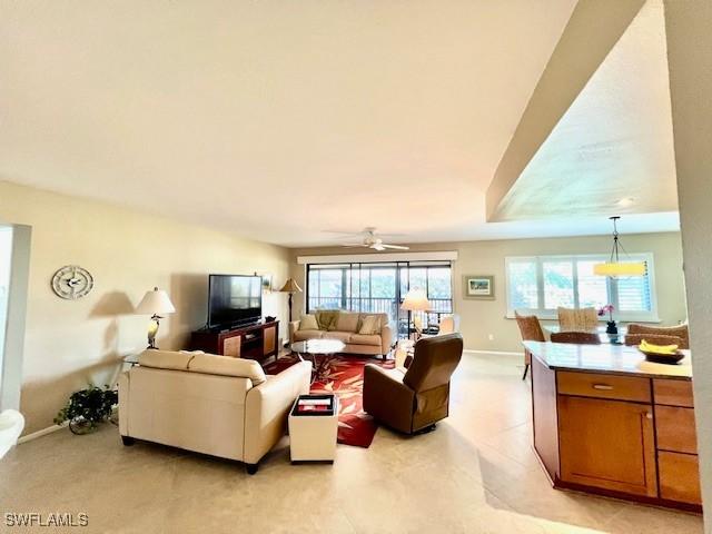 living room featuring ceiling fan and a healthy amount of sunlight