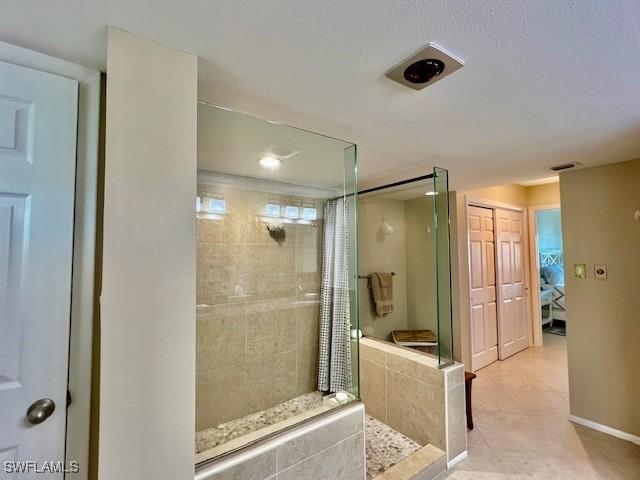 bathroom with tile patterned floors and tiled shower