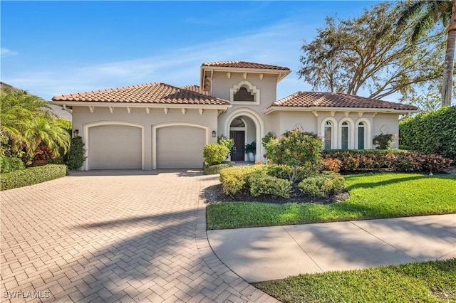 mediterranean / spanish-style house with a garage and a front yard