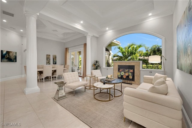 tiled living room featuring a wealth of natural light, ornamental molding, a premium fireplace, and ornate columns