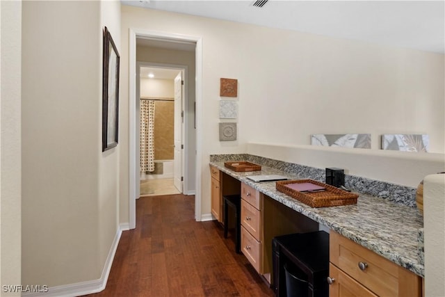 kitchen featuring light stone counters and dark wood-type flooring