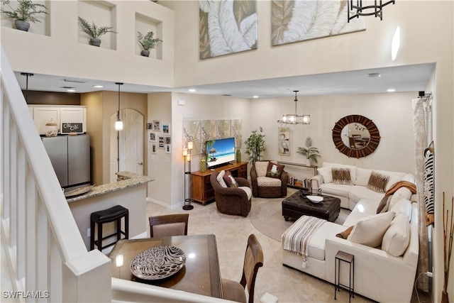 living room featuring a towering ceiling and a chandelier