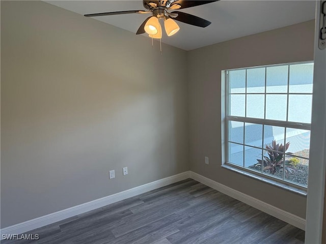 unfurnished room featuring ceiling fan, dark wood-type flooring, and a healthy amount of sunlight