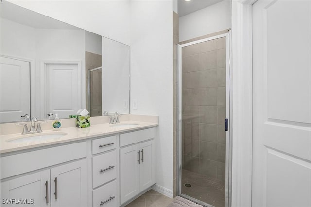 bathroom featuring a shower with door, vanity, and tile patterned flooring