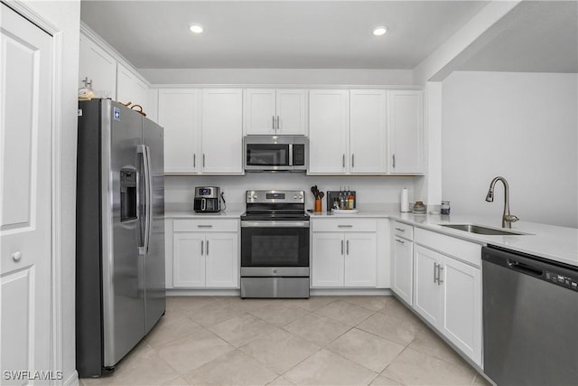 kitchen featuring sink, light tile patterned floors, white cabinets, and appliances with stainless steel finishes