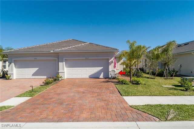 view of front of home with a garage and a front lawn