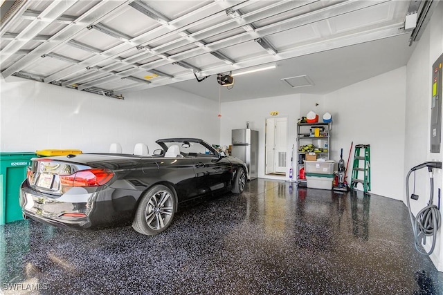 garage with a garage door opener and stainless steel fridge