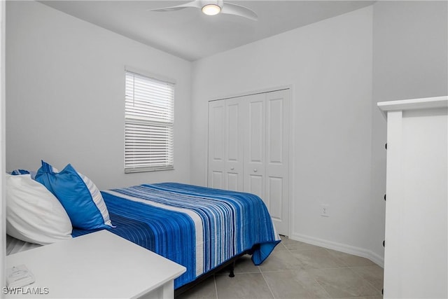 bedroom with light tile patterned floors, ceiling fan, and a closet