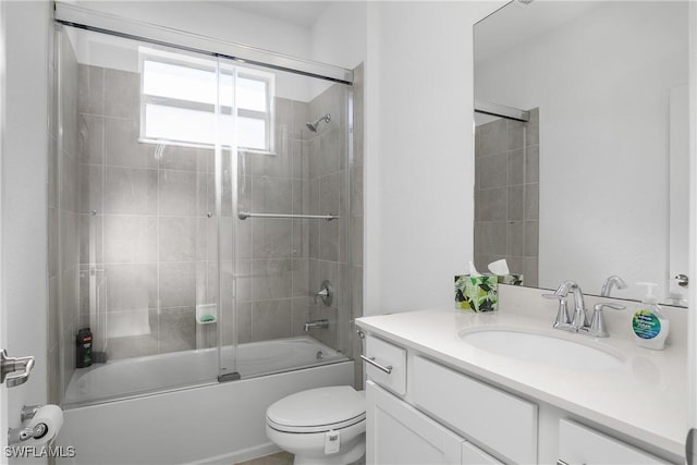 full bathroom featuring vanity, combined bath / shower with glass door, and toilet